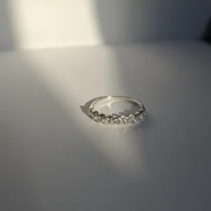 Srebrni prsten sa devet okruglih cirkona u nizu, izrađen od srebra 925, pod prirodnim osvetljenjem.