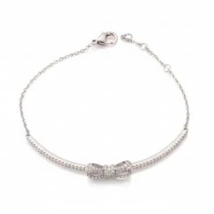 Nežna srebrna narukvica Aria Bow sa centralnim motivom mašne i čvrstim delom optočenim nizom cirkona na beloj pozadini.