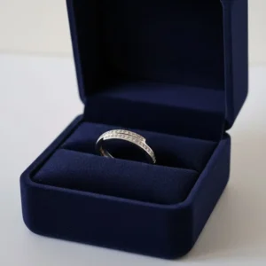 Luksuzan srebrni prsten Ring & Rare sa centralnim pravougaonim cirkonom i bočnim kristalnim detaljima u tamnoplavoj kutiji za nakit.