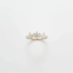 Srebrni prsten Srebrni let sa dva bočna leptira i centralnim cvetom optočenim sitnim cirkonima na beloj pozadini.