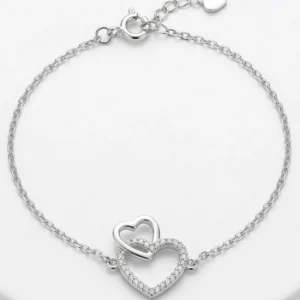 Srebrna ženska narukvica 925 sa motivom dva spojena srca i cirkonima Duplo srce na beloj pozadini.