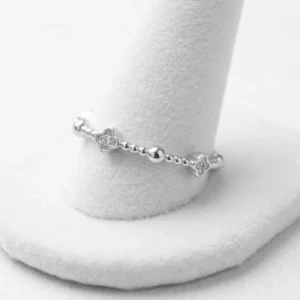 Tanak srebrni prsten sa motivima cvetića ukrašenih cirkonima i sitnim srebrnim kuglicama.